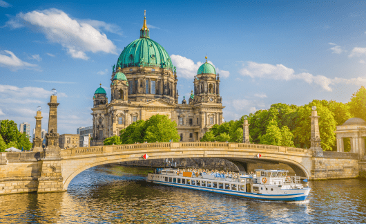 Berlin Cathedral with boat going under bridge.